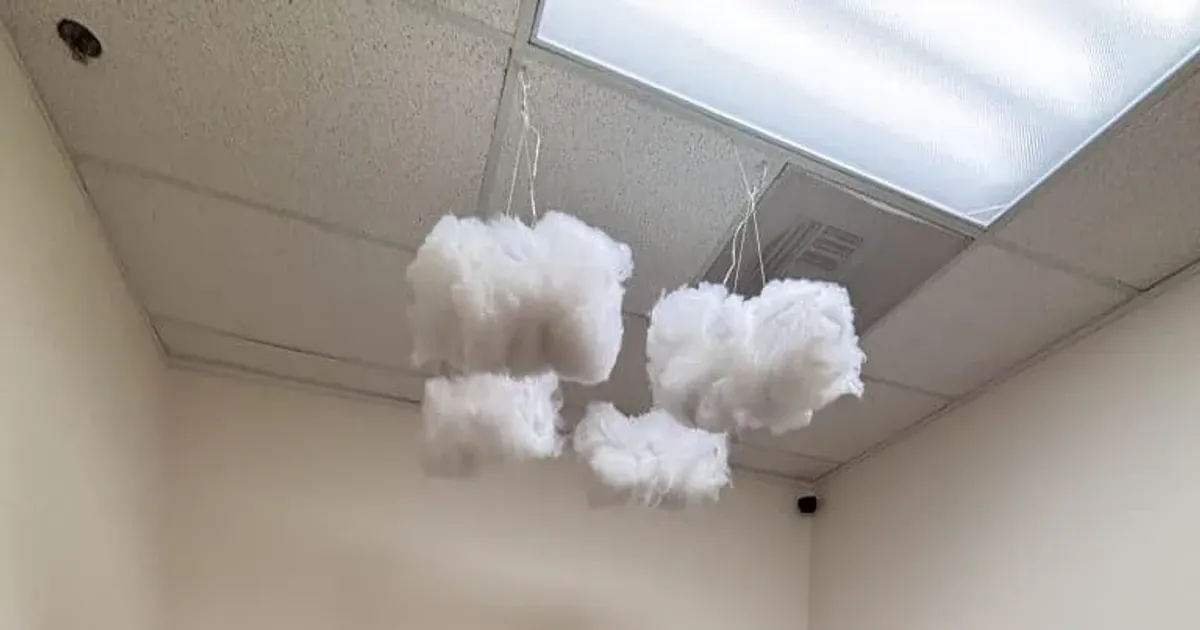 A calm sensory room with textured hexagon wall panels, cotton cloud mobiles and a large bean bag