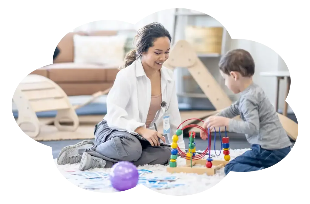 An ABA therapist and a young child playing together with a bead-maze toy during a therapy session
